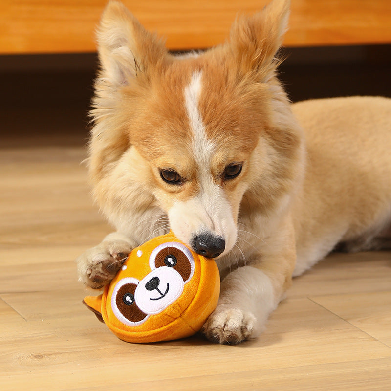 Dog playing with a yellow ball toy on a wooden floor